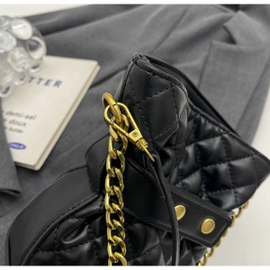 Detail shot of black quilted leather bucket bag with gold chain and metal hardware