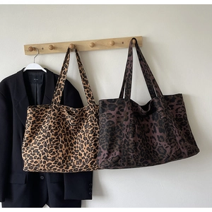 Detail view of large leopard print tote bags in brown and dark purple canvas material