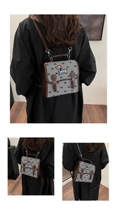 Detail view of houndstooth backpack featuring cute dachshund embroidery and leather buckles