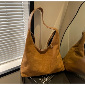 Vue détaillée du sac à bandoulière en daim marron montrant la texture et l'anneau métal