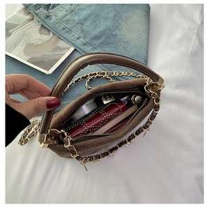 Top view of brown suede handbag showing inner capacity with lipstick and gadgets