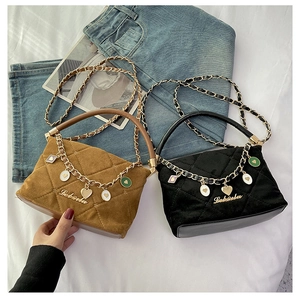 Detail of quilted mini handbags in brown and black with gold chains and heart charms