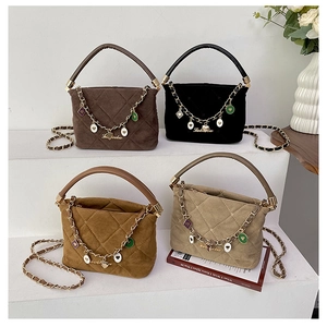 Detailed view of four quilted suede handbags in brown, black, and tan with cute charms