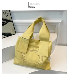 Detail of a large yellow tote bag with lychee texture and circular stitching decoration