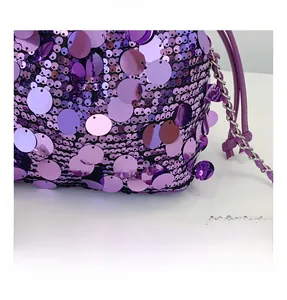 Dettaglio della borsa a secchiello con paillettes viola e tracolla a catena