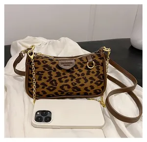 Detailed view of leopard print mini bag with gold chain strap and smartphone size comparison
