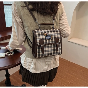 Detail of checkered small backpack with cute cartoon dachshund embroidery on the back