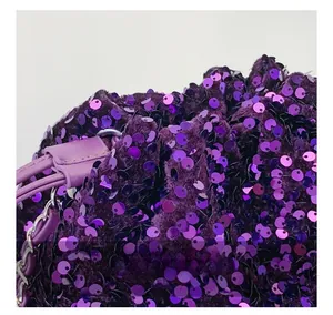 Dettaglio di paillettes viola su velluto con coulisse e catena in metallo argento