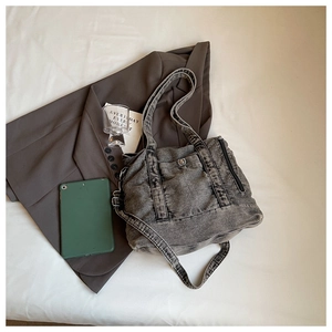 Detailed close-up of charcoal gray washed denim tote bag with vintage texture and strap