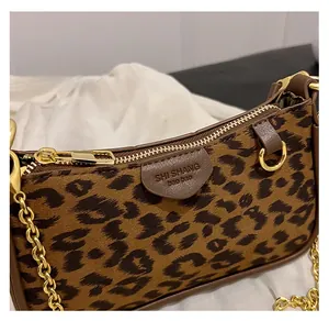 Detail of smooth gold zipper and leopard print faux leather on a square handbag