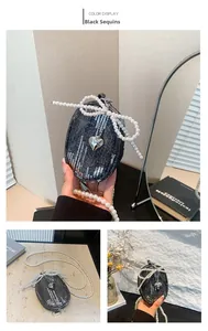 Detail der Denim-Umhängetasche mit silbernen Pailletten, Perlenkette und Herzanhänger
