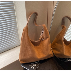 Détails d'un sac hobo en daim marron avec texture souple et finitions métalliques chic