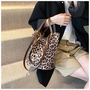 Lifestyle shot of large leopard print bucket bag with long handles and suede texture