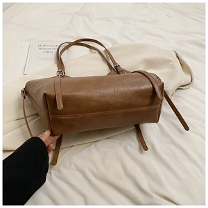 Detailed texture of brown faux leather on a casual tote bag with fine stitching