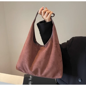 Détail du sac hobo en daim rouge-brun montrant la texture et l'intérieur spacieux