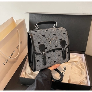 Detail of retro houndstooth handbag with silver bow buckle in elegant gift box setup