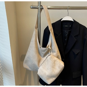 Détail d'un grand sac hobo en similicuir beige avec une petite pochette zippée assortie