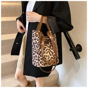Close-up of leopard print bucket bag with brown leather straps and spacious interior