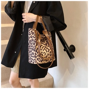 Detail of leopard print bucket bag with leather handles and adjustable shoulder strap