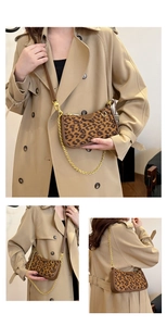 Macro detail of leopard print canvas bag with gold chain strap and brown leather accent