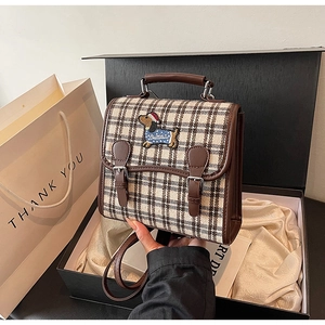Detailed view of vintage plaid backpack with dachshund embroidery in premium gift box setup