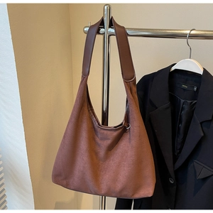 Gros plan du grand sac cabas vintage en daim marron foncé avec bandoulière minimaliste