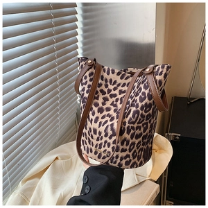 Detail of leopard print bucket bag featuring gold metal MISS KOLY logo and leather handles