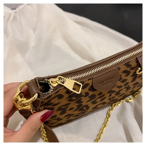 Detail of leopard print mini bag featuring gold zipper and metal chain strap