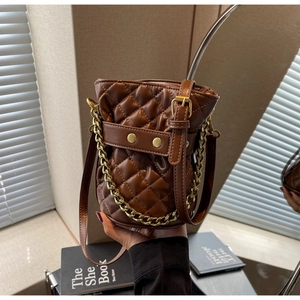Detailed quilted pattern on a brown bucket bag with gold chain and crossbody strap