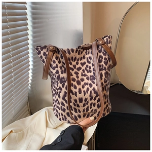 Detail of leopard print bucket bag with brown leather straps and gold logo accent
