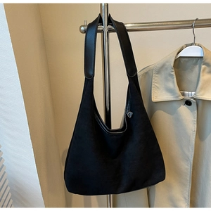 Détail du sac hobo en daim noir avec bandoulière en cuir et anneau en D argenté