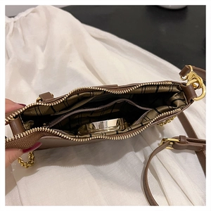 Detailed view of the brown leather bag interior with green lining and gold zippers