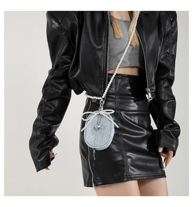 Détail du mini sac bandoulière en denim avec nœud en perles et pendentif cœur métallique