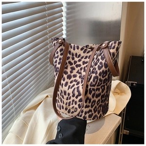 Leopard print velvet bucket bag with brown leather handles and brand logo detail