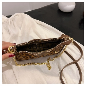 Detail view of leopard print handbag showing striped interior lining and dual shoulder straps