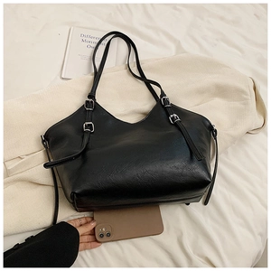 Detail showing the large capacity of the black leather tote bag with silver metal buckles