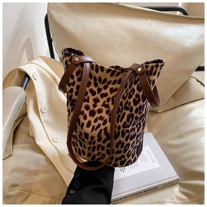 Detail of leopard print bucket bag with brown leather handles on a fashion book