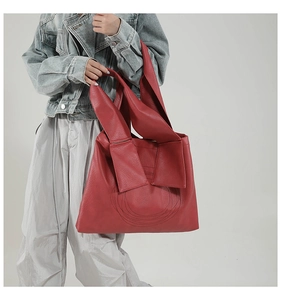 Detail of red large capacity tote bag with bow decoration and lychee texture PU leather