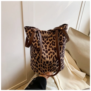 Detail shot of leopard print bucket bag with premium leather straps and metal rivets
