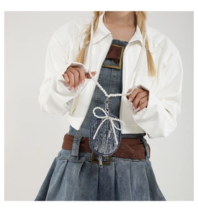 Détail du mini sac en jean avec paillettes, nœud et bandoulière en perles blanches