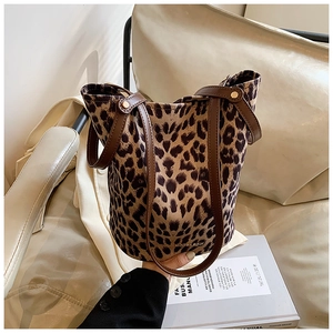 Detail of leopard print bucket bag featuring brown leather handle and brand logo stamp