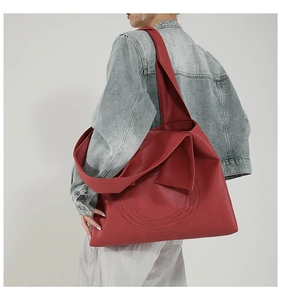 Detail of red leather tote bag showing large capacity and circular quilted stitching texture