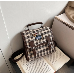 Detail of vintage plaid mini backpack featuring dachshund embroidery and faux leather straps