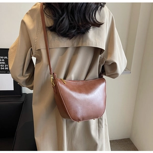 Brown leather hobo bag styled with khaki trench coat for an elegant autumn look