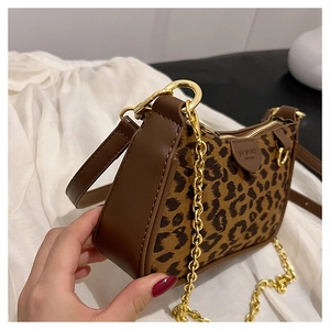 Detail showing leopard print texture with brown leather trim and golden metal chain
