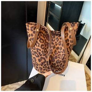 Detail of leopard print bucket bag with brown synthetic leather straps and gold rivets