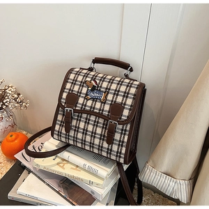 Detail of British vintage plaid backpack featuring a cute dog embroidery with a Santa hat