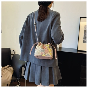 Dettaglio borsa a secchiello rosa con paillettes floreali, coulisse e rivetti