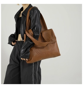 Close-up of caramel brown tote bag with pebble texture and round stitching detail