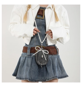 Détail du mini sac en jean avec nœud en perles et sangle perlée style mode Y2K
